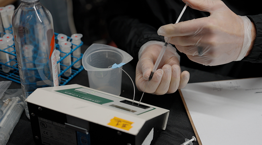 Gatorade Sports Science Institute researcher analyzing sweat sample with laboratory testing equipment to measure electrolyte concentration and sodium levels for female hockey player hydration study